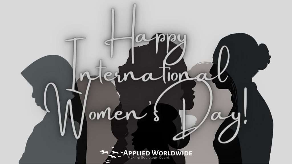 Happy International Women's Day from Applied Worldwide! Title graphic reading "Happy International Women's Day" on top a monochromatic collage of transparent silhouettes of women. 