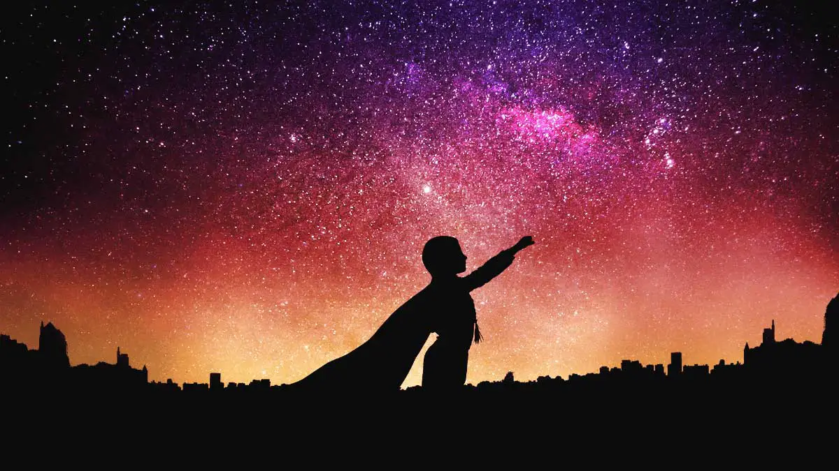 Photo of Superhero Silhouette Against a Bright Orange and Pink Galaxy Sky for Blog Titled Sociology: Unleashing Your Inner Social Justice Hero, No Cape Required