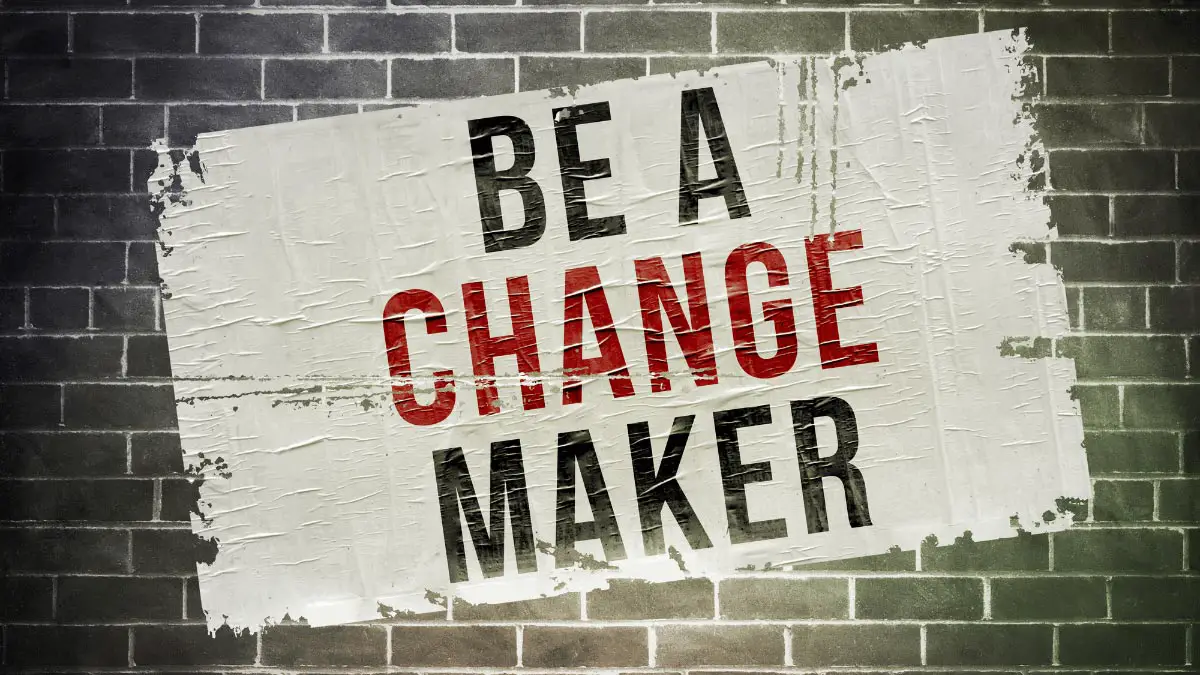 Graphic for Student Essay Titled "why is Sociology Important? Driving Positive Change" Showing a Brick Wall with a Sign Reading "be a Change Maker"