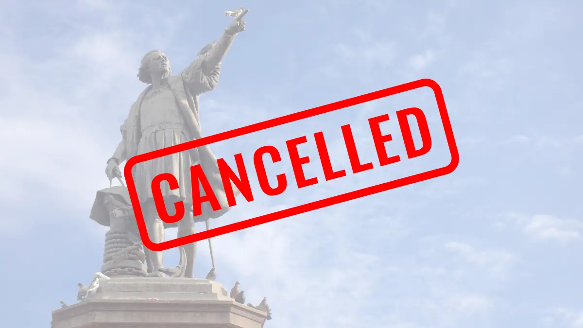 Photo Showing a Statue of Christopher Columbus with a Stamp Reading "cancelled" Across the Image.