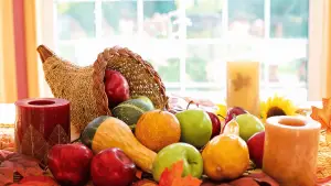 Photo of a Cornucopia Overflowing with Fruit and Chords on a Thanksgiving Table with Bright Daylight Shining in from the Windows Behind for a Blog Titled Thanksgiving Symbols and Symbolic Interactionism